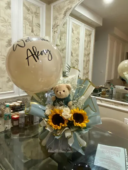 A beautiful and simple welcome gift for baby Akay. This bouquet combines fresh sunflowers with a cuddly teddy bear and a personalized "Welcome Akay" balloon, offering a warm and thoughtful gesture.