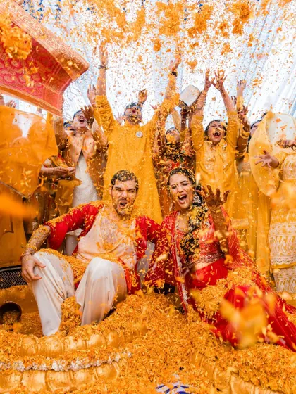 An explosion of joy and color as a couple is showered with marigold petals during their vibrant Haldi ceremony in Udaipur.