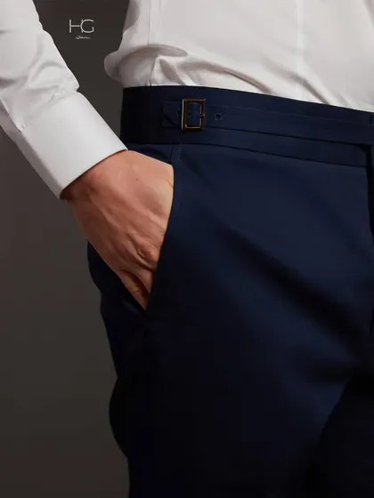 A close-up on the bespoke buckle-tab closure of my navy trousers. It's these small, refined details that signify true craftsmanship and luxury.