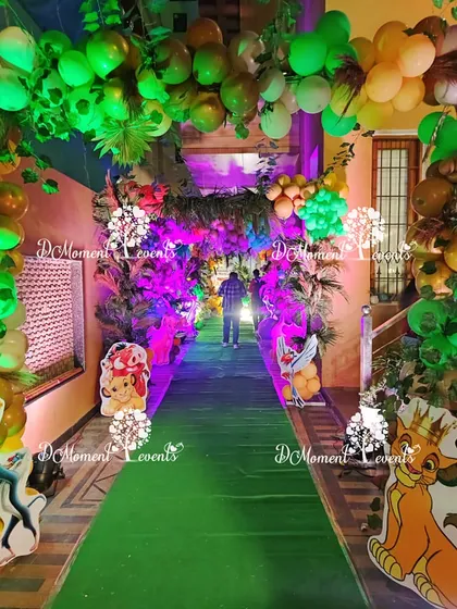 A view down the decorated jungle pathway, showing the immersive experience created with props, lighting, and a green carpet runner.