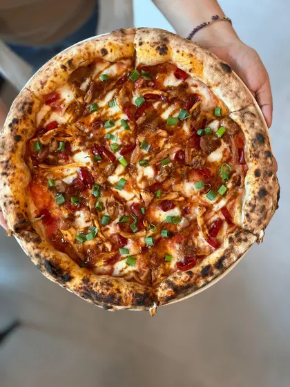 Our Adobo Chicken pizza, held up and ready to be served. A true masterpiece.