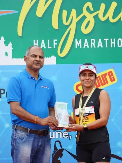 A duplicate of image 24. Receiving my trophy at the Mysuru Half Marathon. It's an honor to be recognized on the podium.