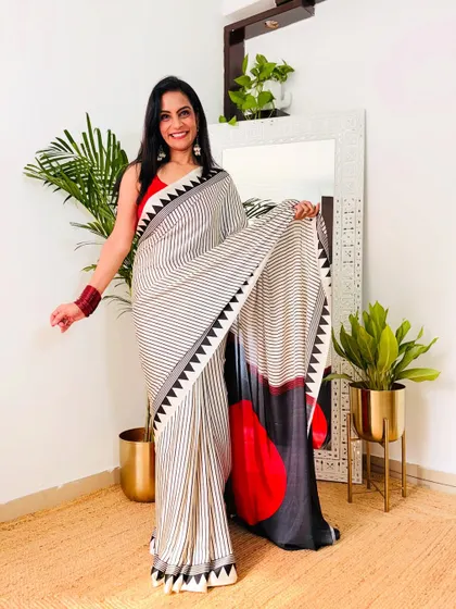 I love the modern, geometric print on this crepe saree. The combination of black, white, and red is very striking. It's a great saree for making a style statement.