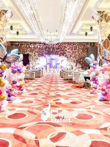 We created a grand butterfly-lined walkway to welcome guests. These colorful balloon pillars topped with large butterfly balloons transformed the hotel ballroom into a magical pathway for Aarṇa's fairyland party.