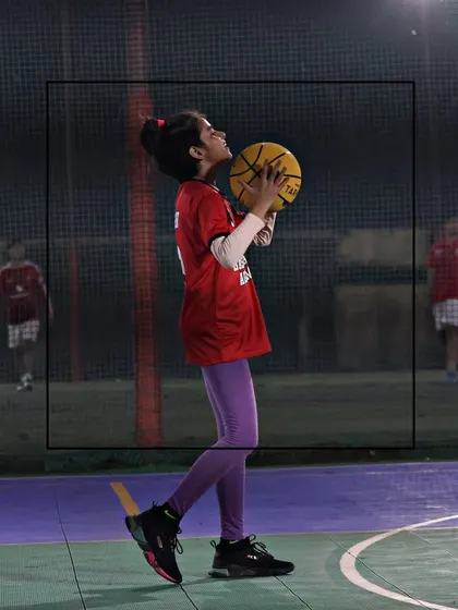 A young girl prepares to shoot, showing her focus and determination. We create a space where every player can grow and feel motivated.
