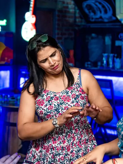 Two guests dancing together, sharing a fun moment. The neon signs in the background add to the pub's cool aesthetic.