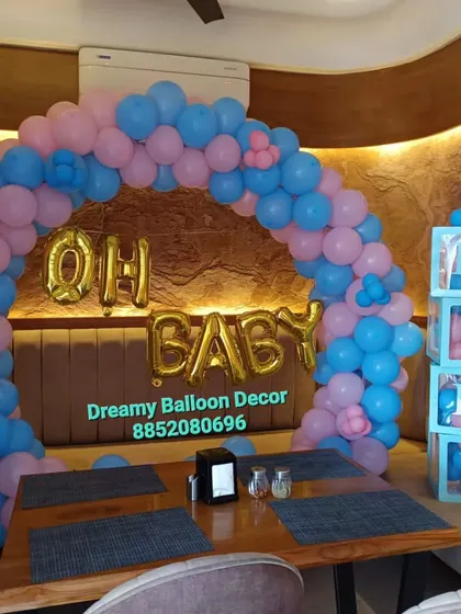 This is a simple yet elegant baby shower arch I set up in a restaurant. The pink and blue balloons are perfect for a gender-neutral theme, and I added "Oh Baby" foil balloons and matching B-A-B-Y boxes.