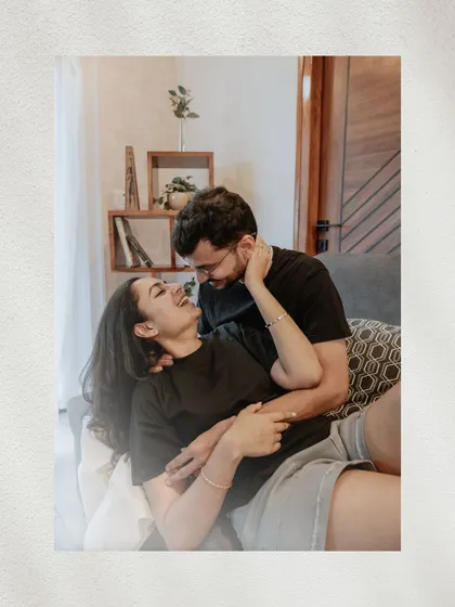 A soft-focus, dreamy shot of the couple laughing and cuddling on the couch, creating a feeling of warmth and intimacy.