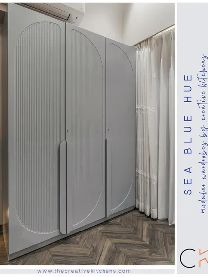 Our modular wardrobe in a calming sea blue hue features intricate fluted shutters with a European membrane finish. The arched design and integrated handles create a statement of impeccable, modern design.