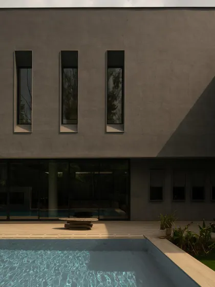 The facade's rhythmic, narrow windows are set against the smooth concrete, overlooking the pool. This detail highlights the project's brutalist-inspired aesthetic and its connection to the landscape.