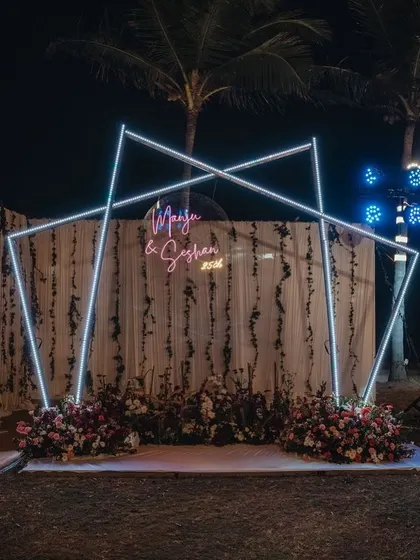 Another angle of the geometric neon sign backdrop, this time set up for an outdoor event with palm trees in the background. It's a versatile piece that works in many settings.