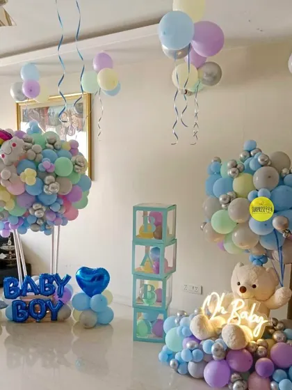 A full room decoration for a baby boy's welcome. This setup includes hot air balloon bouquets, "BABY" blocks, and ceiling balloons to transform the entire space.