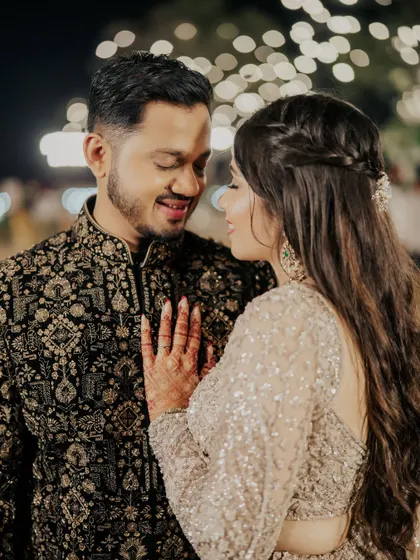 An intimate moment between the couple. Her soft, sparkling makeup looks stunning under the evening lights.