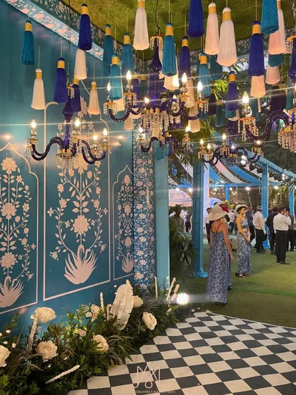 A beautiful walkway at the Bar Palladio themed event, with patterned walls, hanging tassels, and blue crystal chandeliers creating a grand and immersive experience.