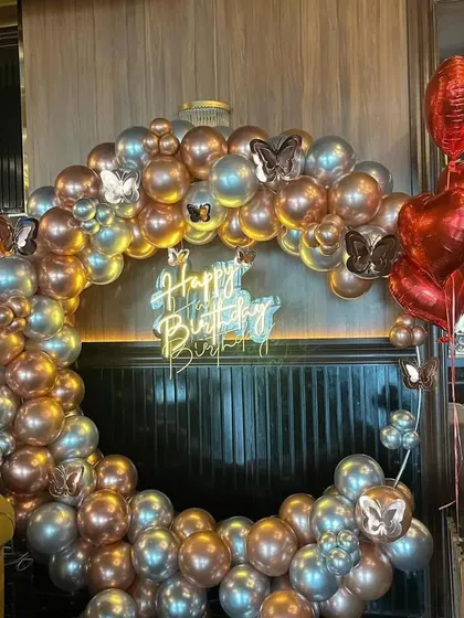 A stunning ring decoration made with chrome silver and rose gold balloons. The metallic finish and butterfly accents give it a very modern and chic look, perfect for a stylish birthday or event.