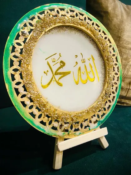The green and gold filigree plaque displayed on its stand.