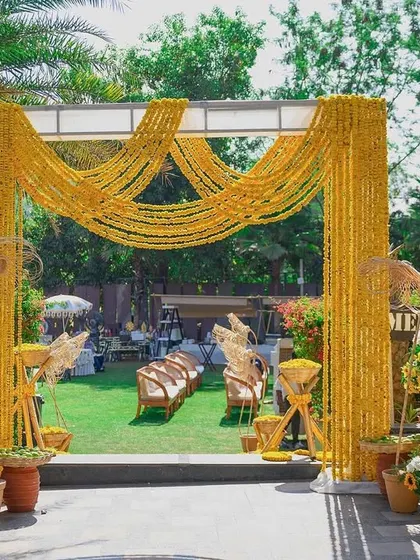 The entrance to a vibrant haldi celebration, framed by an arch of marigold garlands, setting a festive and traditional tone.