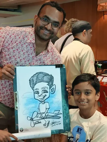 A father and son duo with their new caricature. It's a great memento from a fun Sunday brunch.