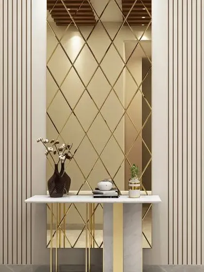 This sophisticated entryway uses a diamond-patterned mirror and vertical wall slats to create a sense of height and glamour. The marble and gold console table adds to the luxurious feel.