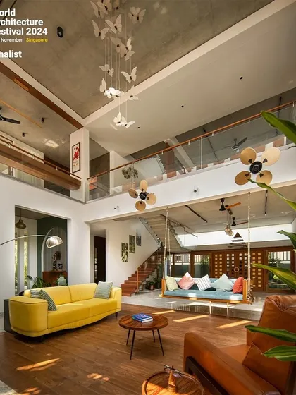 The living room is designed to be a dynamic family space, with visual connections to the floor above and the gardens on either side.