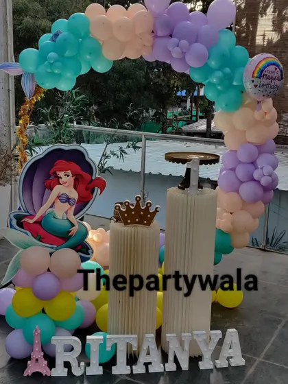 A simple and sweet mermaid theme with a pastel balloon arch, perfect for an outdoor or poolside party.