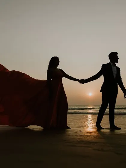 A beautiful silhouette of a couple walking on the beach at sunset. This is a timeless shot for any pre-wedding album, and I can help you find the perfect flying gown for it.