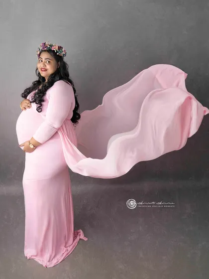 Capturing movement and grace. The flowing fabric of the gown adds a dynamic and artistic element to this portrait, making the image feel alive and full of energy.