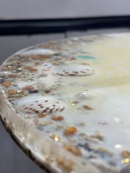 The edge of the table shows the beautiful lacing effect of the resin, mimicking the waves washing up on the shore.