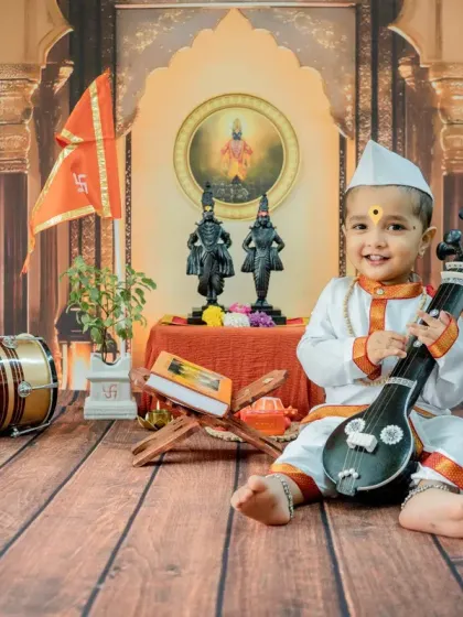 A playful shot with the baby holding a miniature veena. I use a variety of props in my cultural photoshoots to create diverse and engaging images.