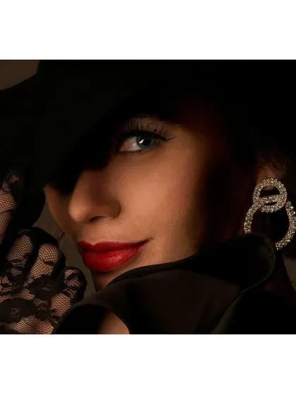 A classic, glamorous portrait for a jewellery shoot. The dramatic lighting, elegant pose, and focus on the diamond earrings create a timeless and sophisticated look.