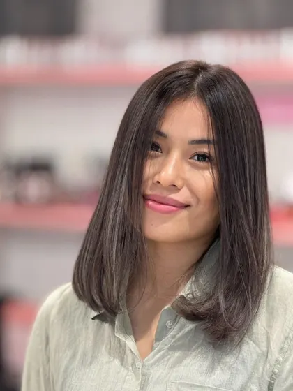 A beautiful ash hair color on a medium-length cut. The cool tones are sophisticated and modern, perfectly complementing her look.