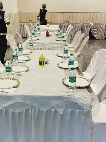 A clean, all-white theme for a 'dawat'. Our staff, wearing branded vests, are seen ensuring the setup is immaculate.