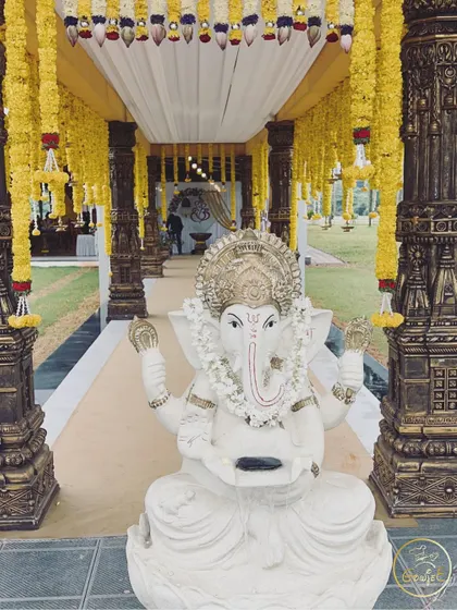 A welcoming Ganesha statue at the entrance of a wedding, decorated with marigold garlands.
