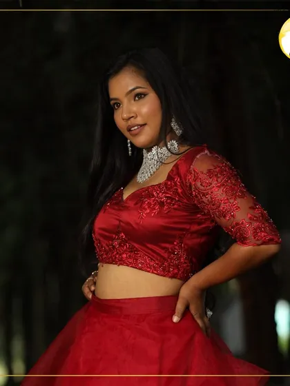 A bold and beautiful look for a photoshoot or a night out. The makeup features a classic winged liner and a bright, confident expression, paired with a stunning red lehenga.