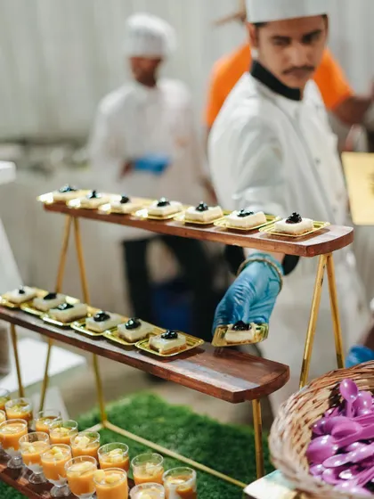 A chef carefully arranges a dessert spread, featuring a variety of mousses and pastries. Our dessert counters are as delightful to look at as they are to eat.
