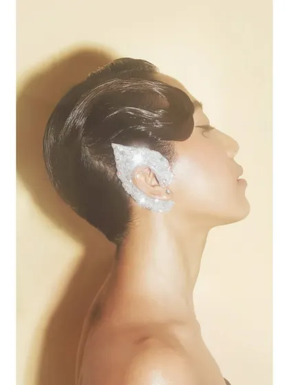 A profile shot highlighting a stunning, crystal-encrusted ear cuff. This image demonstrates how beauty photography can also be used to showcase accessories in a creative and striking way.