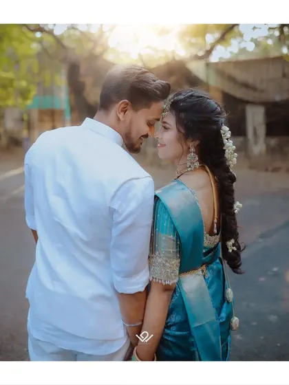 A beautiful back-shot of a couple in traditional blue and white attire, sharing an intimate gaze.