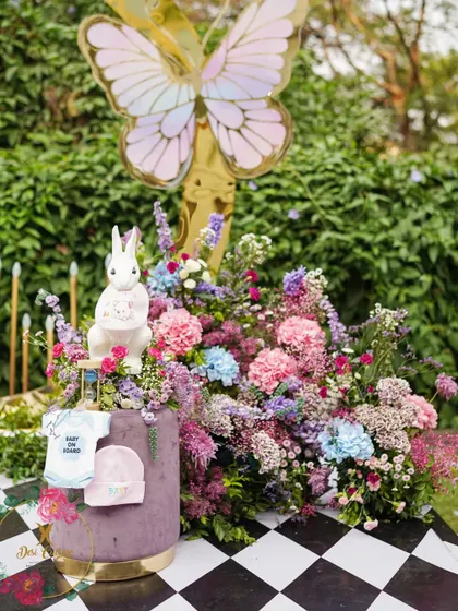 More adorable details from the baby shower, with baby clothes and props integrated into the floral arrangements on the main stage.
