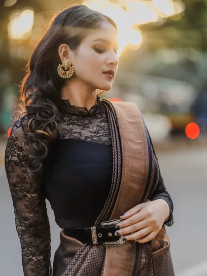 A close-up bridal portrait with the warm, out-of-focus lights of the city at sunset. The golden light and bokeh effect create a dreamy and sophisticated look.