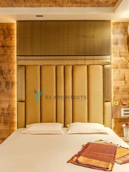 In the master bedroom, we combined a tall, upholstered headboard with rustic wood-paneled walls. This mix of soft and hard textures creates a cozy, cocoon-like feeling, perfect for a restful retreat.