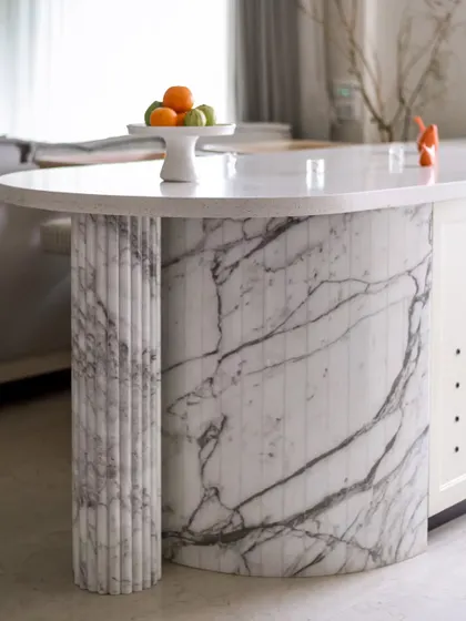 This half-round serving counter, crafted entirely from marble, is a statement of luxury. The extended countertop is supported by a beautifully carved fluted column, making it a true visual centerpiece.