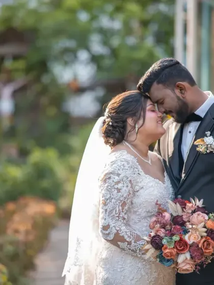 A close, intimate portrait of the newlyweds in a beautiful garden. The warm sunlight and their happy expressions make this a perfect wedding day memory.