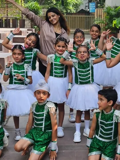 The Kids Jazz batch posing with their instructor, Arushi. This picture captures the fun and excitement of recital day, with students in their green and white costumes, ready to perform.
