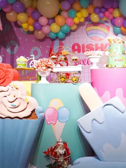 A creative angle of the Candyland setup, showing the giant ice cream and cupcake props. These oversized elements make for fantastic photo opportunities.
