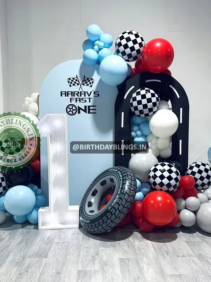 A "Fast One" theme with a different color scheme, using red, light blue, and white. The light-up number '1' and tire prop are key elements.