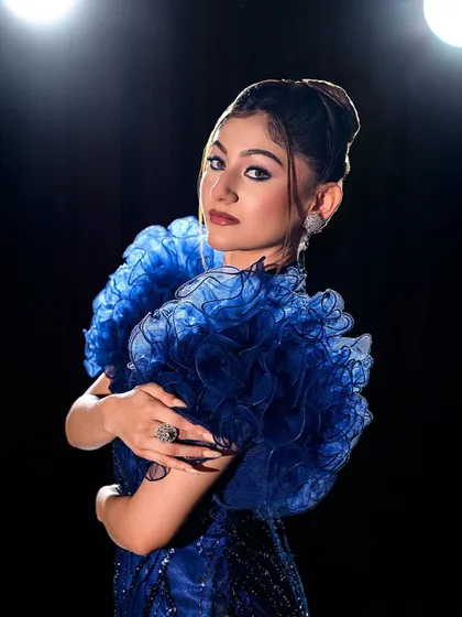 A close-up of the ruffled sleeves, which are the highlight of this stunning blue gown.
