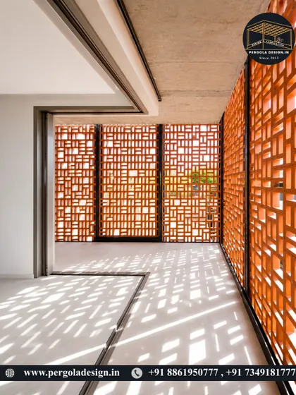 Sunlight streams through a terracotta jali wall, casting intricate shadow patterns on the floor. This demonstrates how jali screens can be used to create dynamic and beautiful light effects within a space.