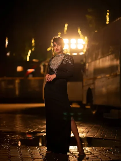 A dramatic, full-length shot of Sanjanaa Anand, using a spotlight to create a cinematic and powerful image.