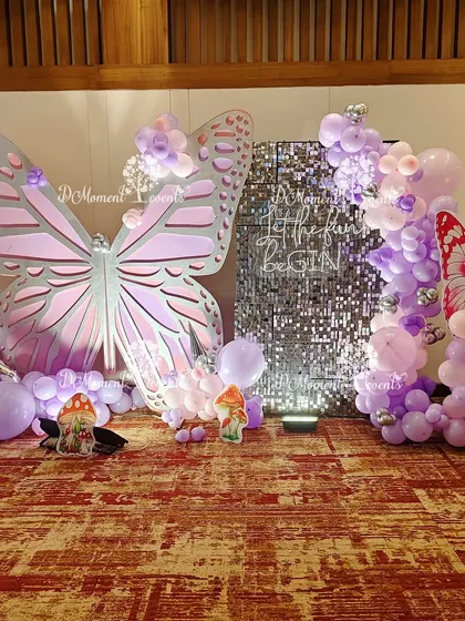 Another angle of the butterfly and sequin wall photo booth, highlighting the mix of textures and the addition of smaller butterfly and mushroom props.