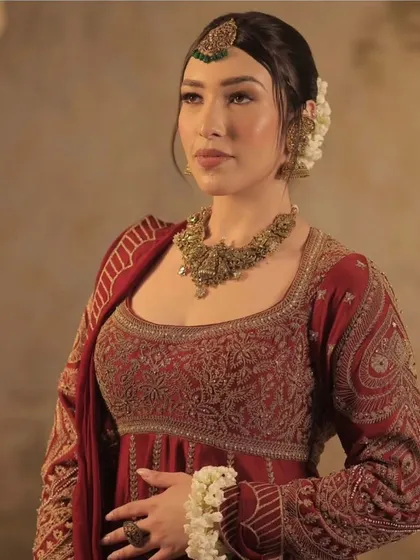 A portrait of a model wearing a traditional anarkali with her hair in a classic gajra bun, a perfect look for festive occasions or a wedding.